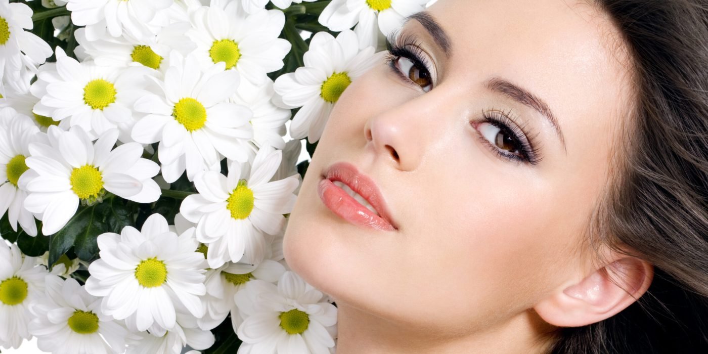 Sexy face of young beautiful girl with flowers - white background